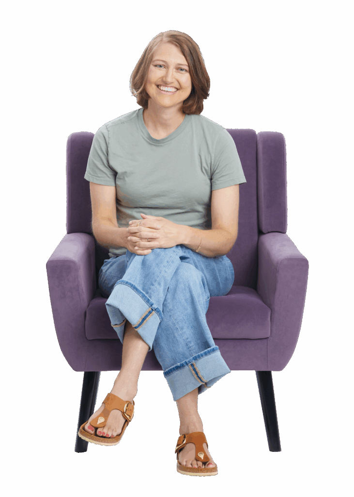 Young woman sitting in chair smiling.
