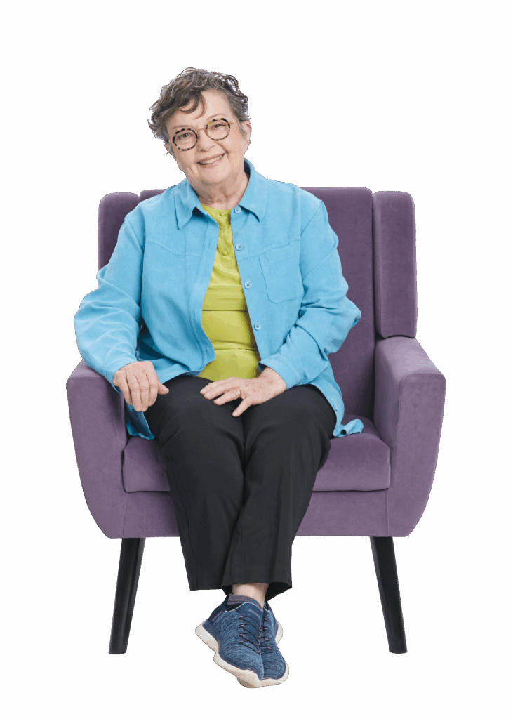 Senior woman sitting in chair smiling.